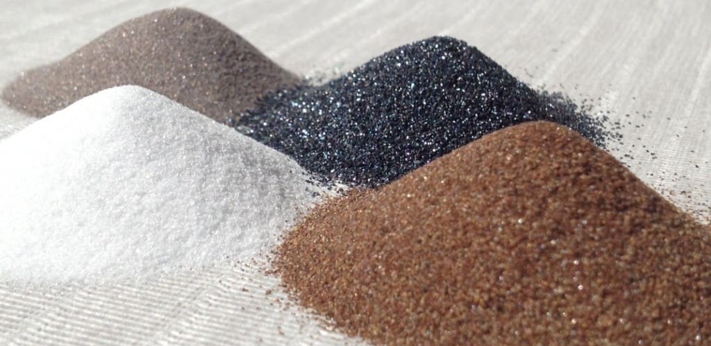 Loose abrasive grit blast materials